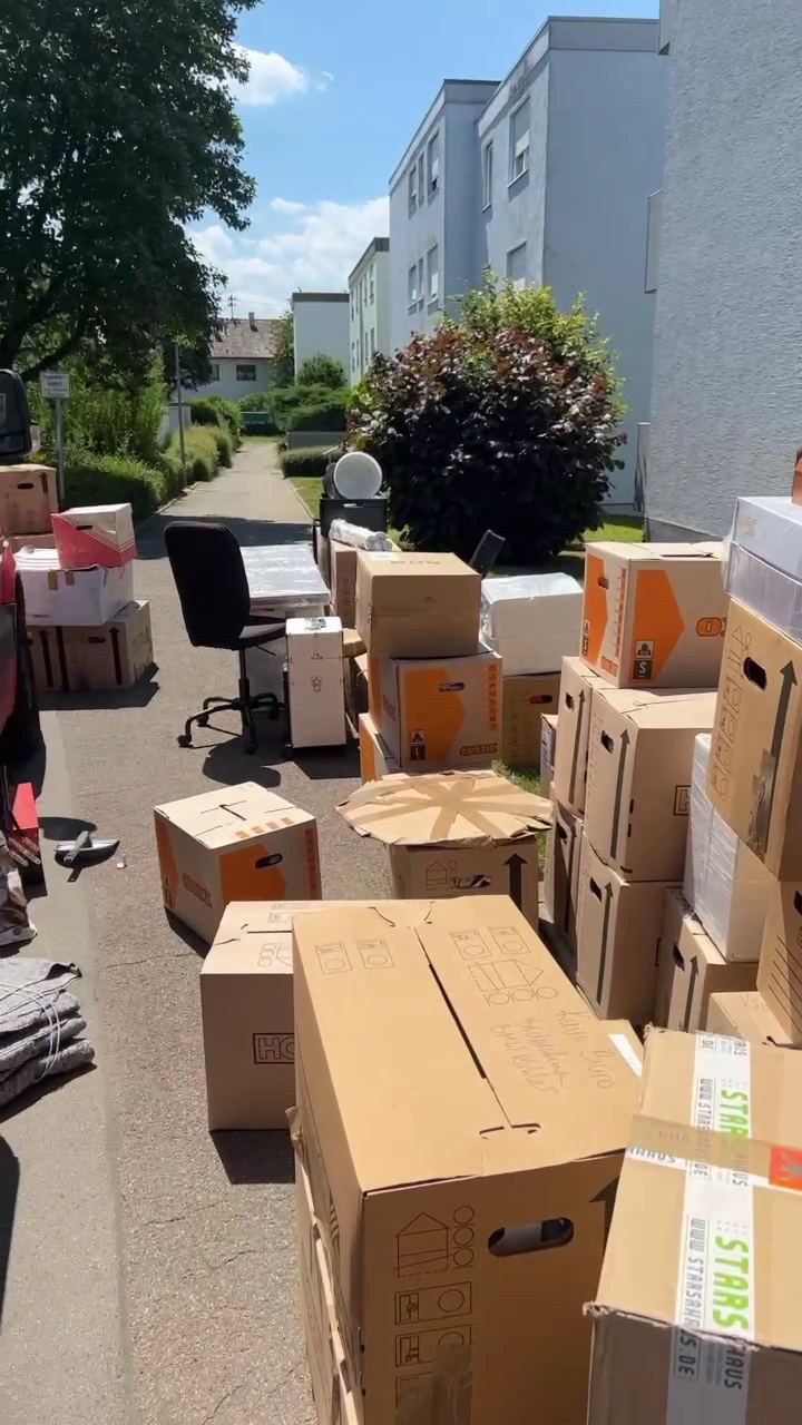 Umzugskartons vor einem Wohnhaus